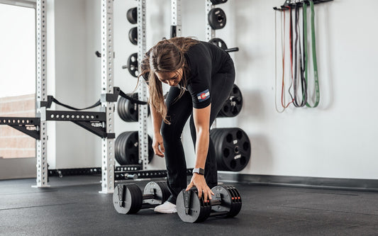 An athlete sets up for dumbbell high pulls with QuickDraw™ adjustable dumbbells.
