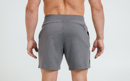 Back view of model wearing the heather cool gray REP Versa Shorts.