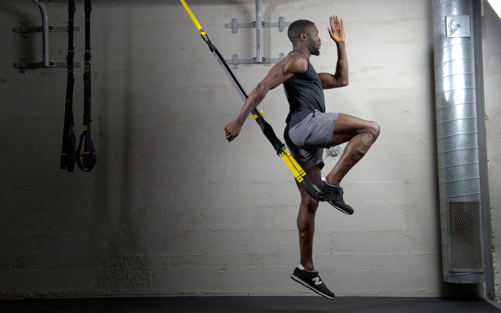Action shot: Athlete utilizing the foot cradle on the TRX® CLUB4 to perform jumping split squats