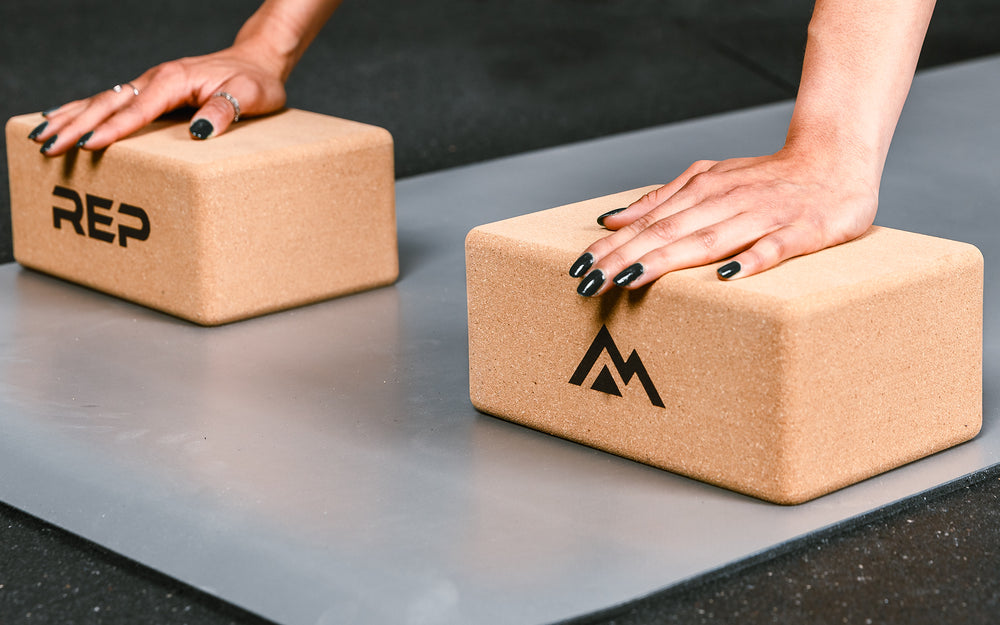 up close of hands on yoga blocks cork