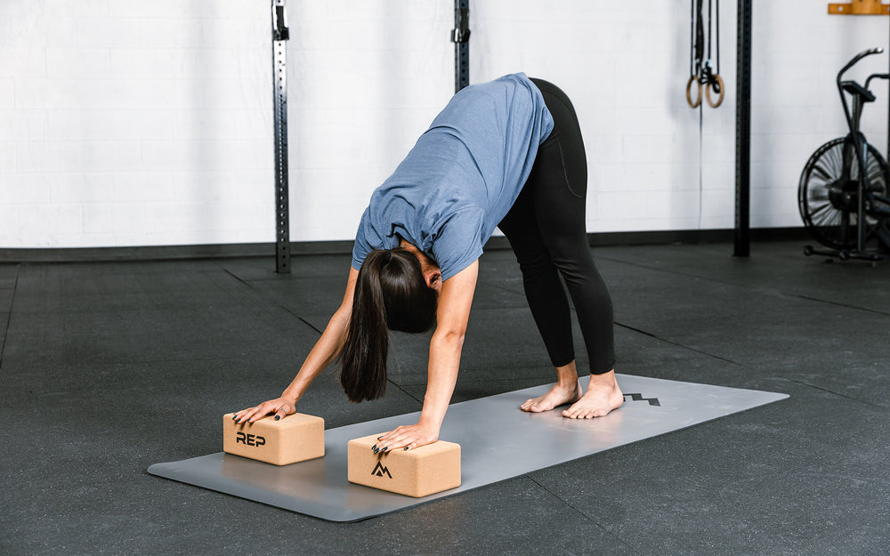 Athlete performing a yoga pose with REP's cork yoga blocks.