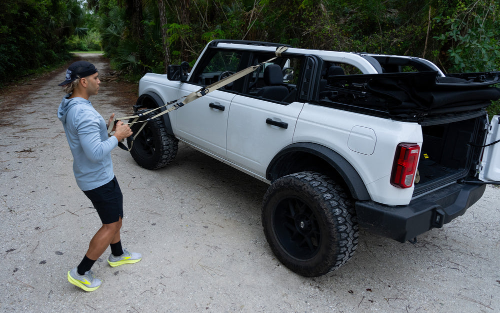 Action shot: Athlete installing the TRX Tactical Suspension Trainer® to the top of a vehicle