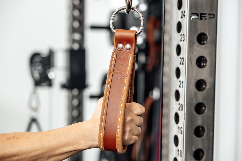 An athlete gripping the REP USA Leather Single Handle Cable Attachment in Brown