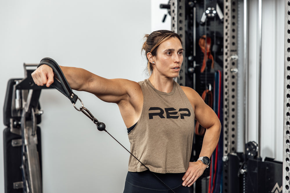 An athlete performing a cable lateral raise with the REP USA Leather Single Handle Cable Attachment in Black