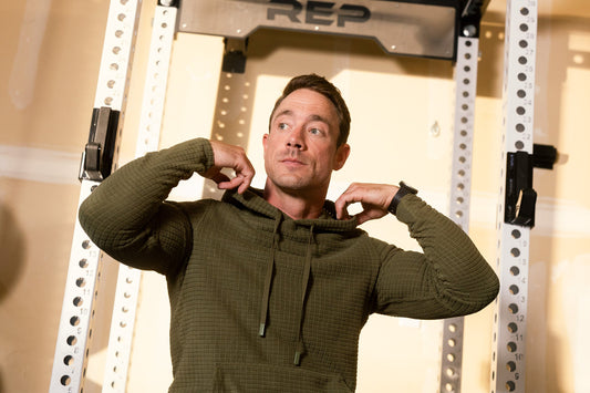 Athlete adjusts their hoodie in the gym.