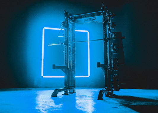 A REP Fitness power rack with a barbell.