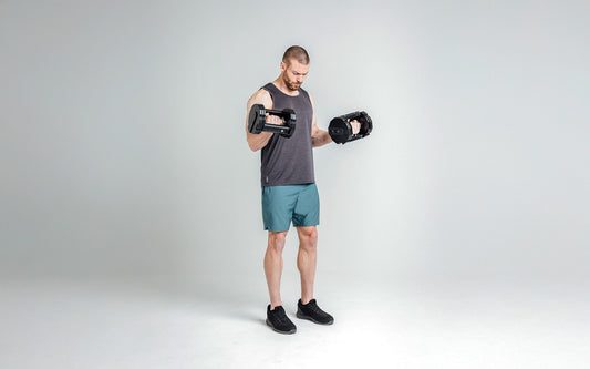 Athlete does supinated dumbbell curls.