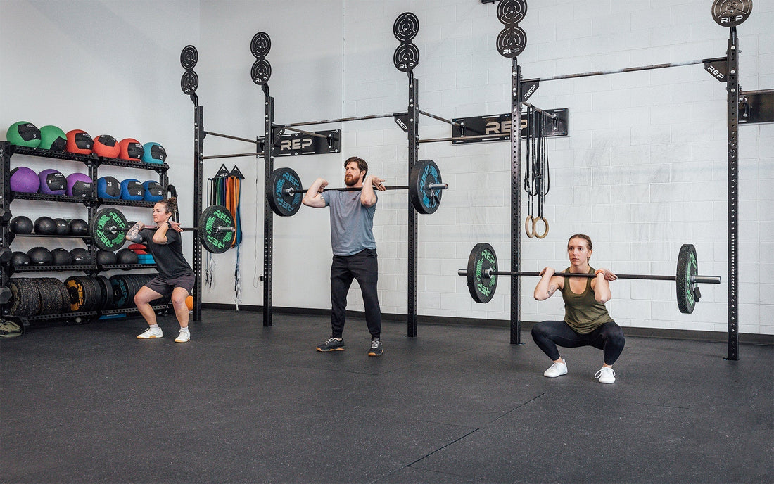 Three athlete use REP barbells for front squats.
