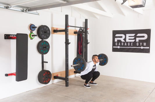 Man doing squats in his garage gym