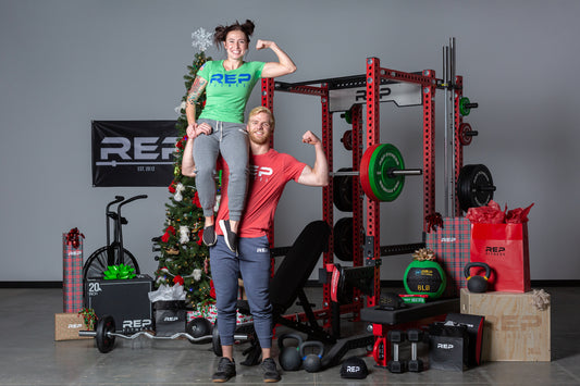 Two lifters posing near a power rack