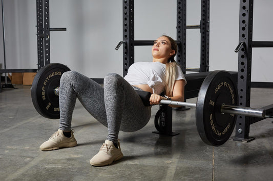 A woman performs a barbell hip thrust.