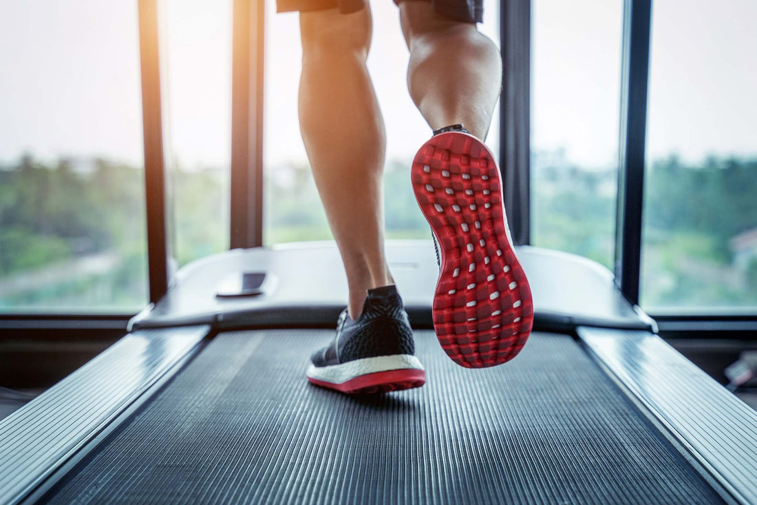 A close up shot of shoes as an athlete runs on a motorized treadmill.