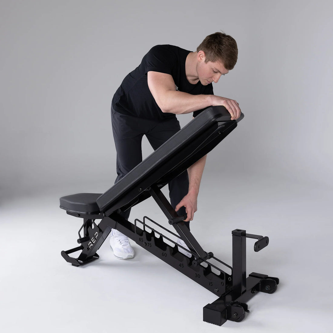 Man adjusting a ladder-style adjustable bench