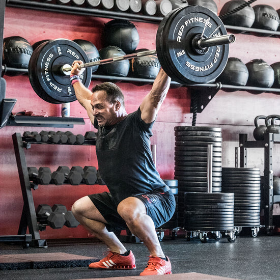 Man doing an overhead press with a barbell