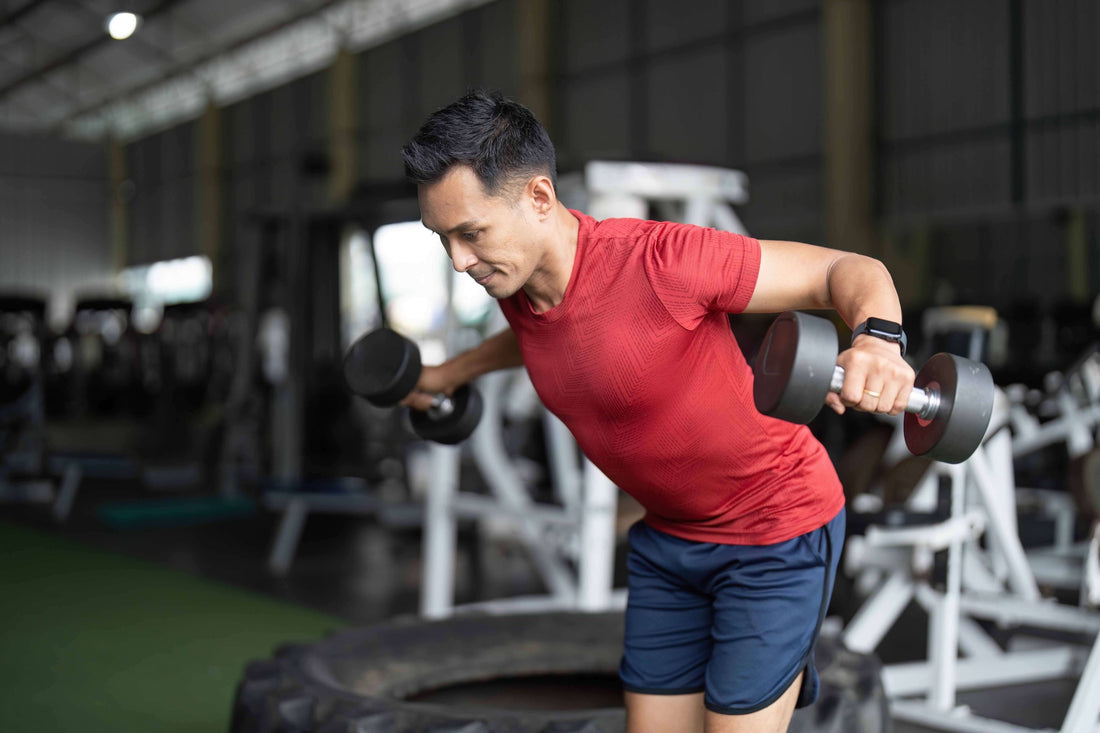 Man executes a standing dumbbell fly.