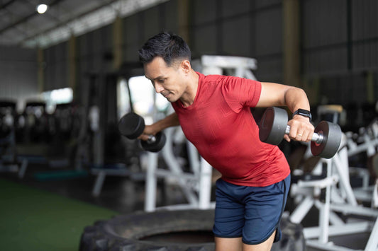 Man executes a standing dumbbell fly.