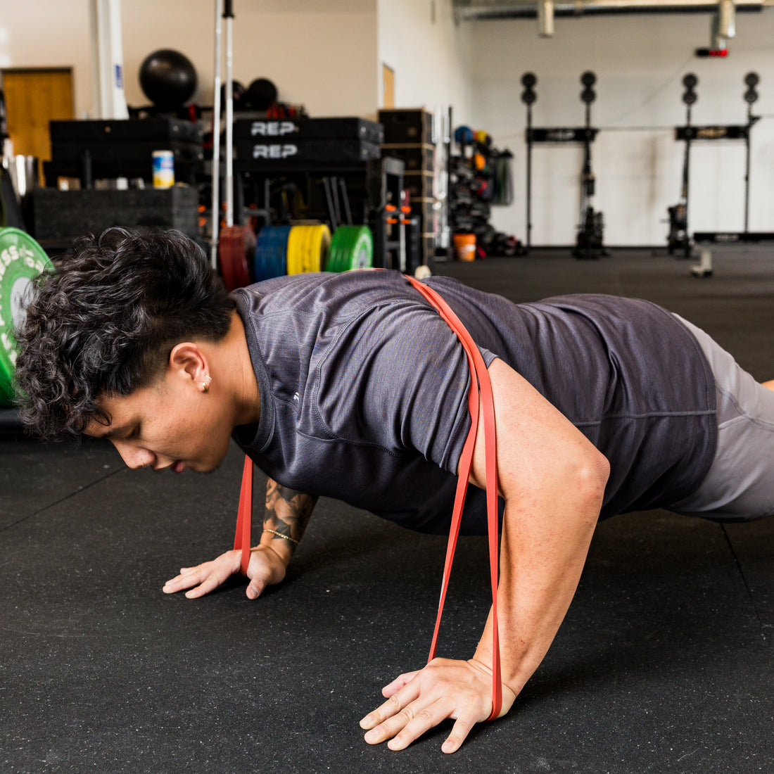 Athlete using the REP Fitness Resistance Bands 2.0 in banded push-up