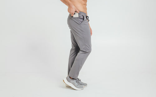 Side view of model sliding his iPhone into the side hip pocket of the cool gray REP Felix Pants.