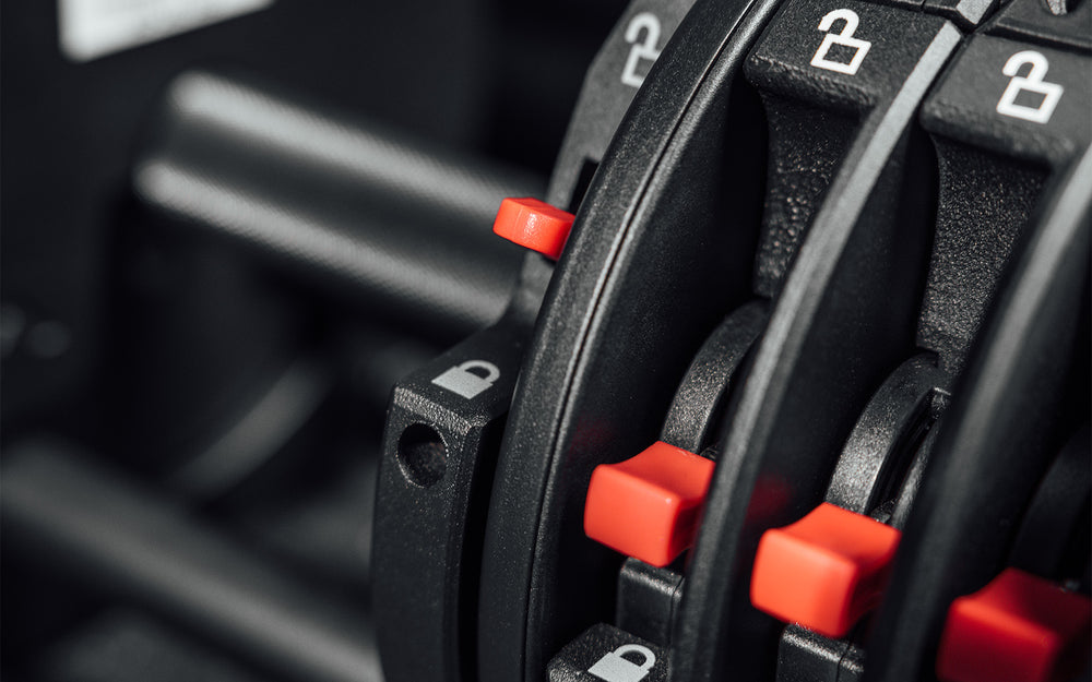 Close-up view of the red switches which serve as the locking mechanism when selecting the amount of weight for your REP Fitness QuickDraw Adjustable Dumbbell (KG).