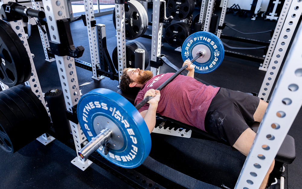 Person benching inside a rack using the Colorado Short Bar