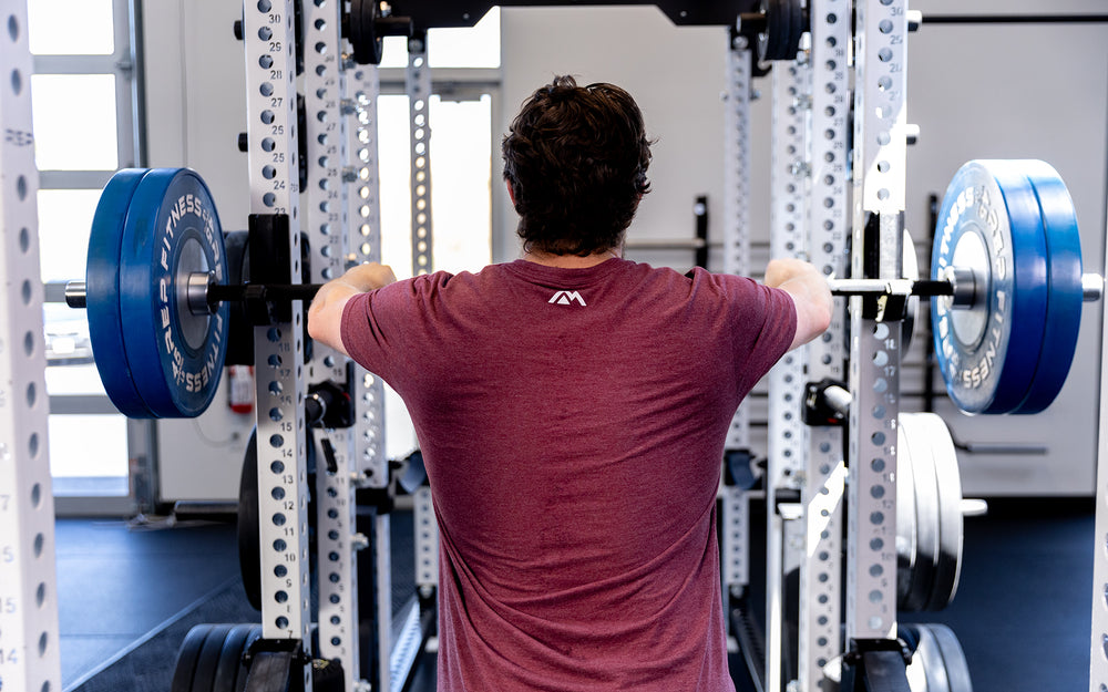 Shot from behind a person getting ready to lift with Colorado Short Bar on a rack