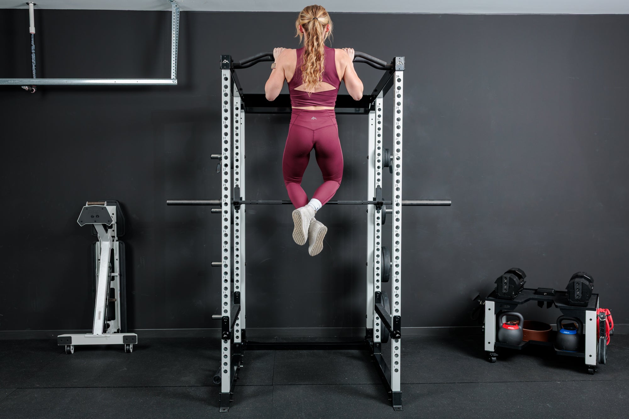 Athlete doing pull-ups on the multi-grip pull-up bar on the REP Fitness Altitude™ Power Rack