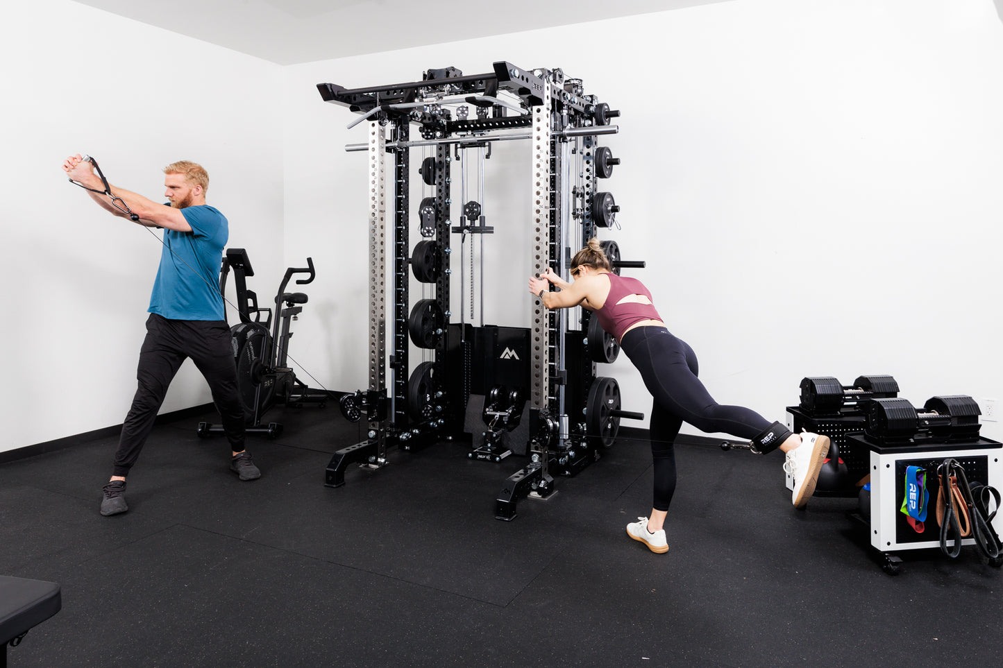 Two people performing cable machine exercises on the Summit™ All-In-One Ares™ 2.0 Upgrade Kit  in a gym setting.