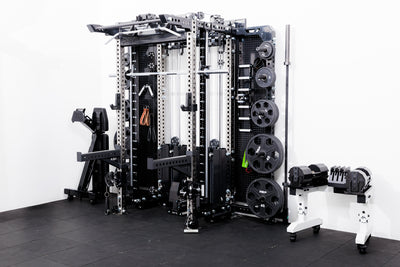 Gym equipment including a Smith machine rack attachment  on a Summit™ All-In-One Ares™ 2.0 Wall-Mounted and weight rack on a black floor with white walls.