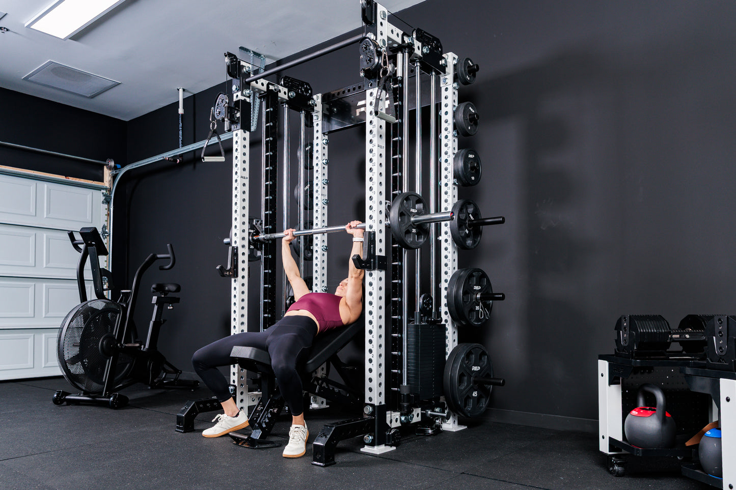 Women using the Smith Machine Rack Attachment for incline bench on the Summit™ All-In-One Trainer with Athena™in a home gym setting.