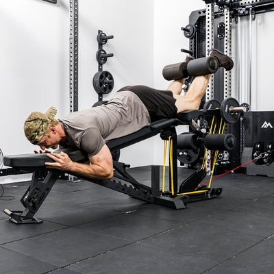 Athlete using the Leg Extension & Leg Curl Bench Attachment Cable Kit with resistance bands