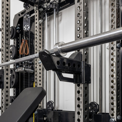 A barbell resting on the short Spotter Arms 2.0 set up in a racked position