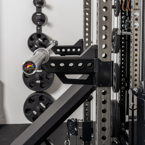 Side shot of a barbell resting on the short Spotter Arms 2.0 set up in a racked position