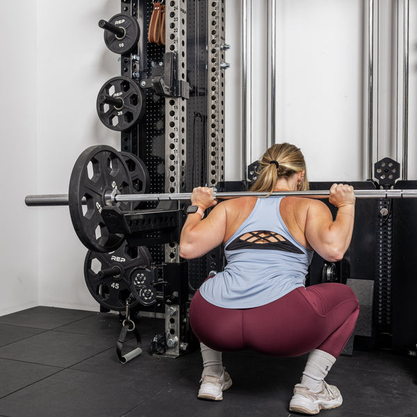 Athlete doing front squat with the short Spotter Arms 2.0 below the bar
