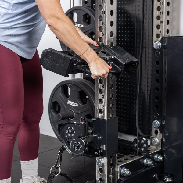Athlete installing the short Spotter Arms 2.0 on a PR-5000 rack