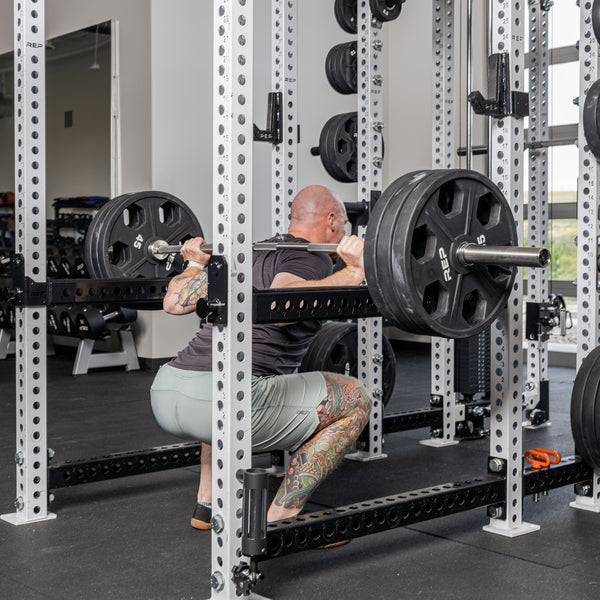Athlete squatting with the Flip-Down Safeties 2.0 below the bar