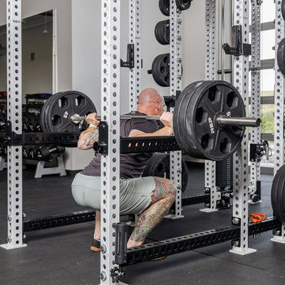 Athlete squatting with the Flip-Down Safeties 2.0 below the bar