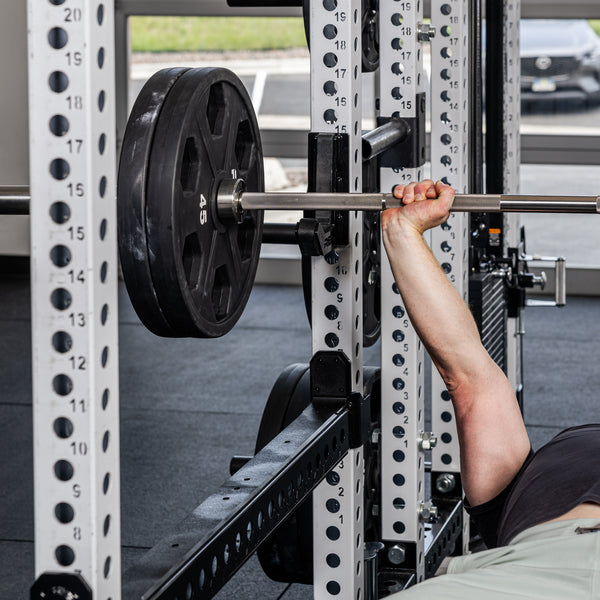 Athlete bench pressing with the Flip-Down Safeties 2.0 below the bar