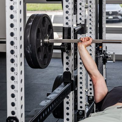 Athlete bench pressing with the Flip-Down Safeties 2.0 below the bar