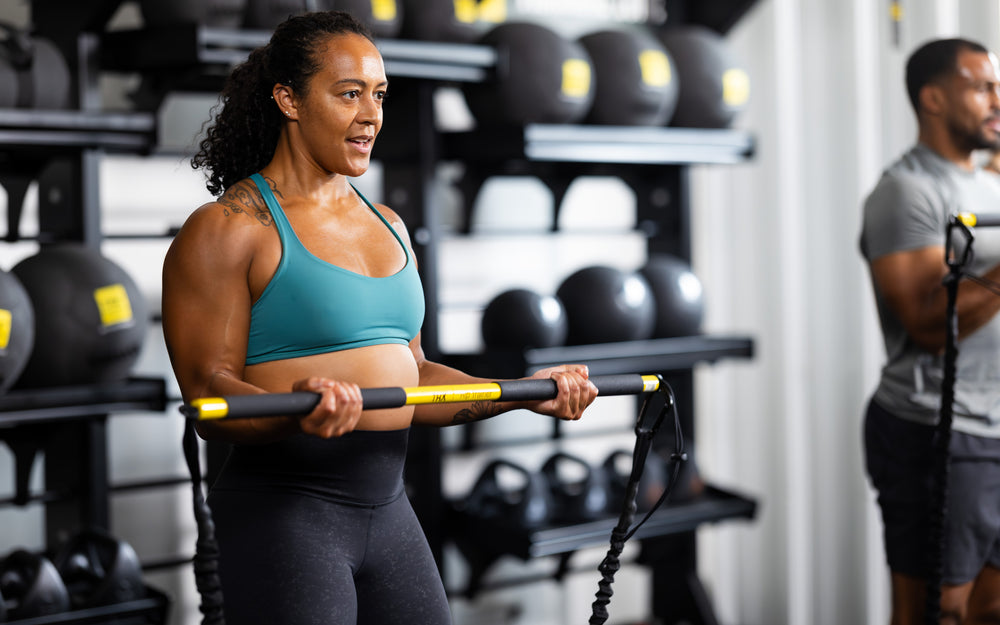 Side shot: Athlete curling the TRX® Rip Trainer™ in front of them against resistance