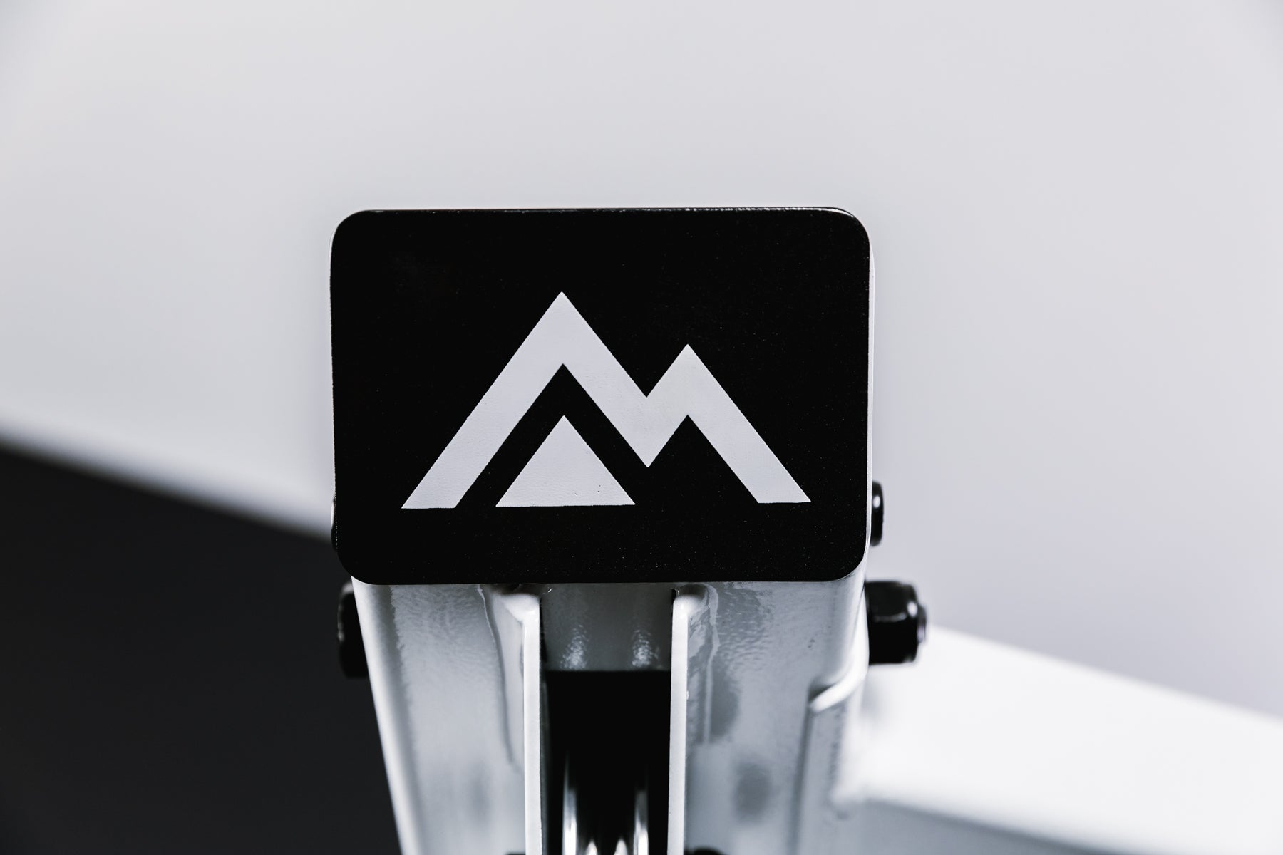 Close-up image of a white REP mountain logo on a black endcap for the white version of the Arcadia™ max