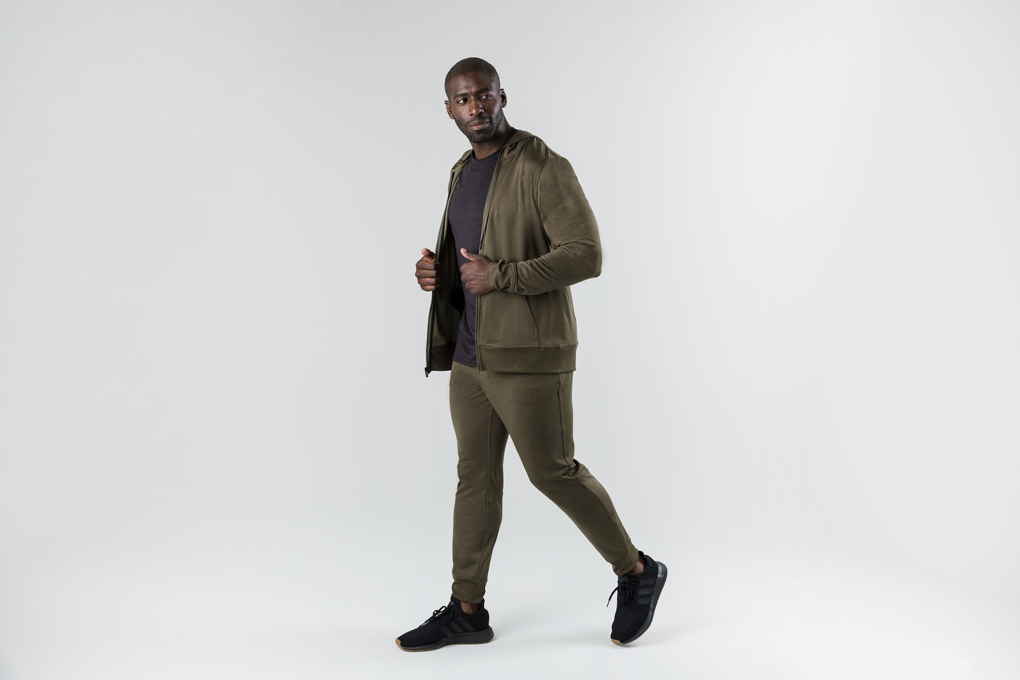 A man wearing the Attis Jacket in 
Heather Olive