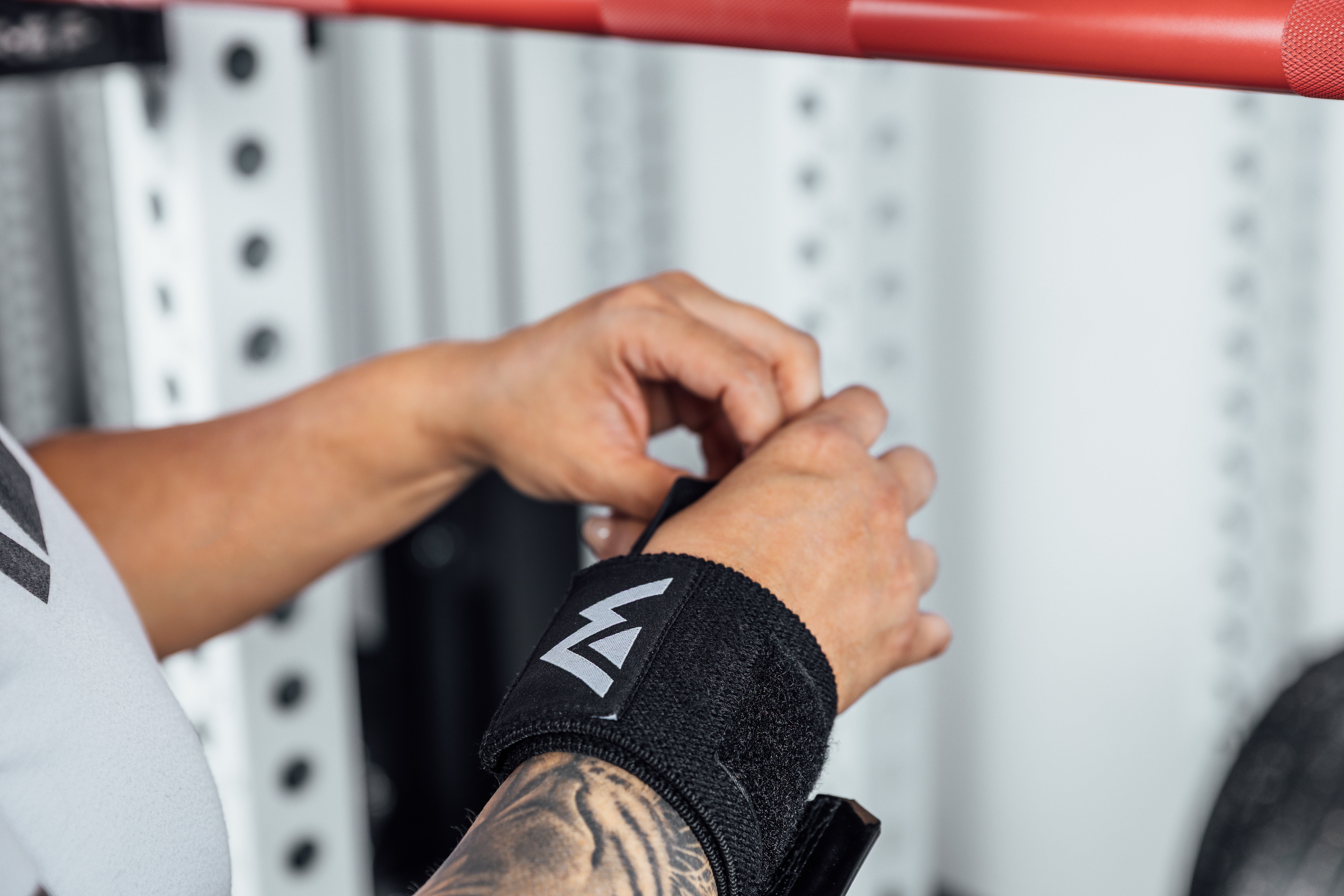 Close up shot of an athlete adjusting the thumb loop of the REP Wrist Wrap