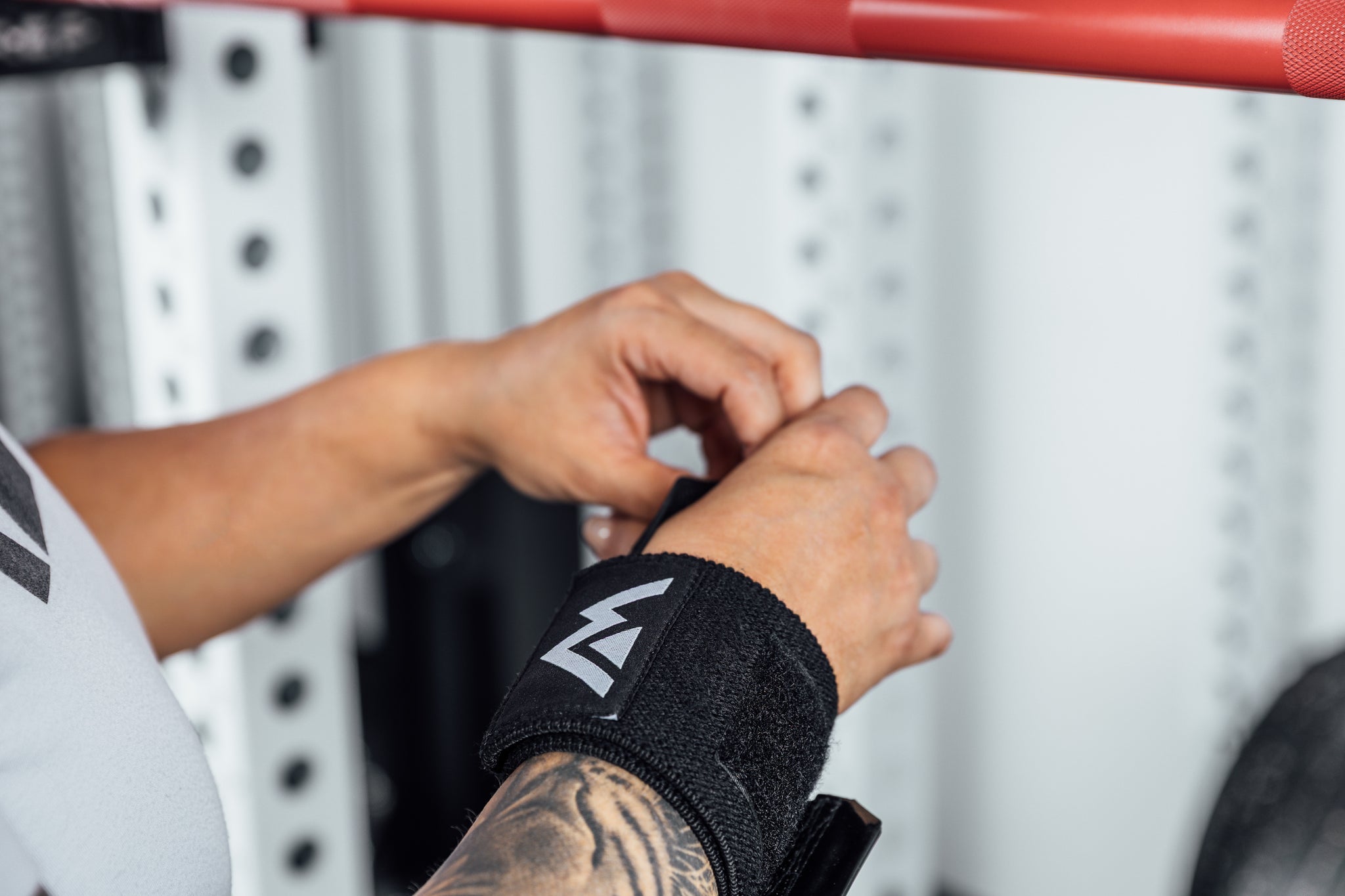 Close up shot of an athlete adjusting the thumb loop of the REP Wrist Wrap