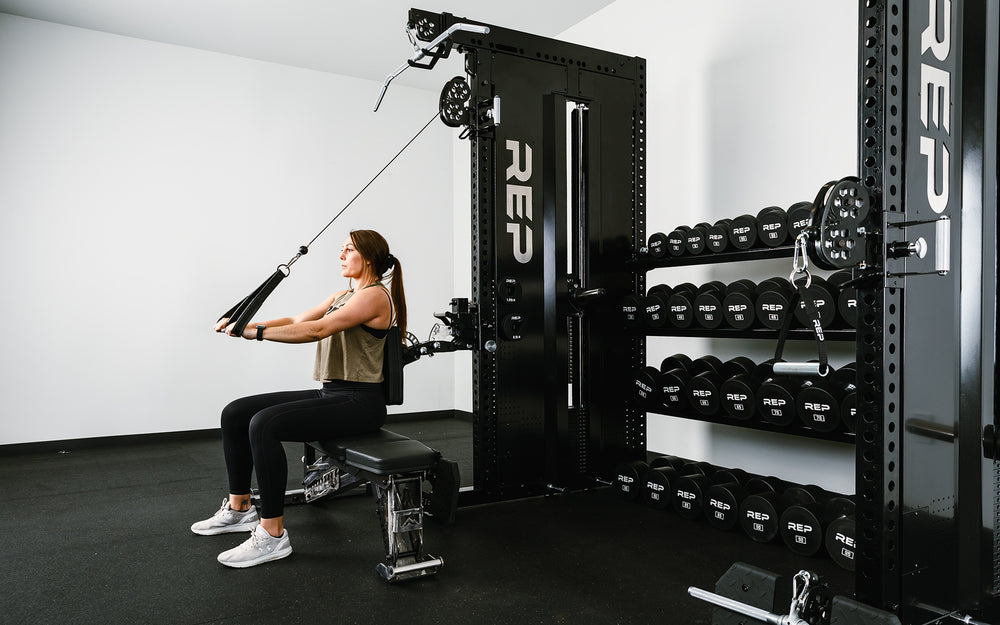 Woman doing exercises on a bench with the aid of Pegasus™ Attachment connected to the Adonis™ Cable Tower.