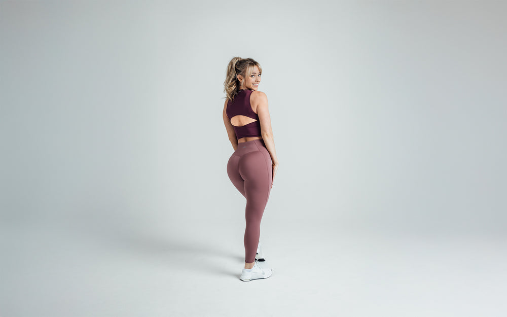 Back shot of an athlete striking a pose while wearing the REP Rhea Tank in Wine.