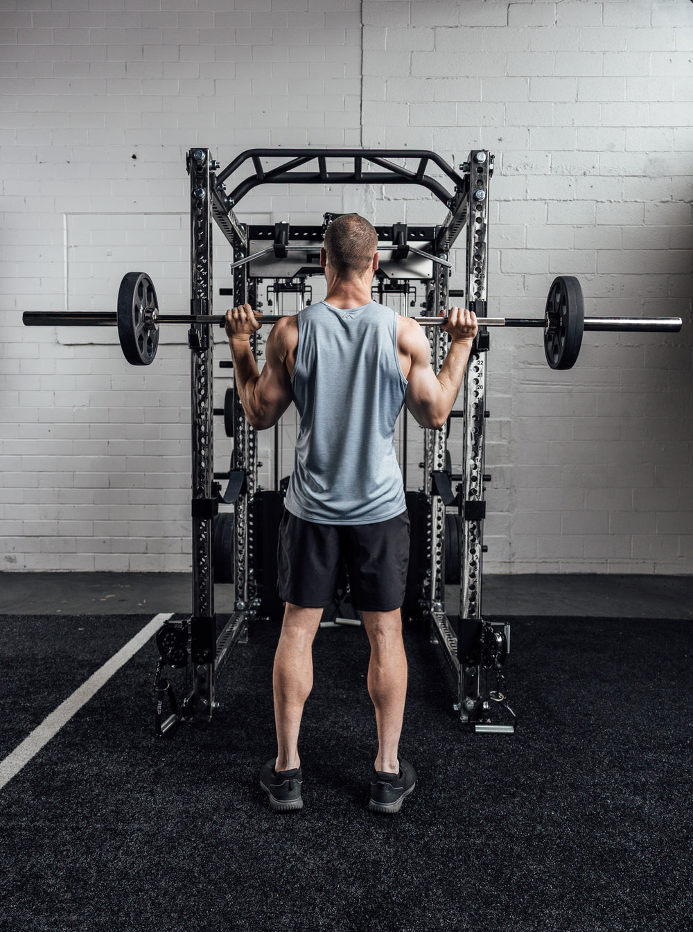 Behind an athlete lifting, wearing Heather Dusty Sigmatech Tank Top