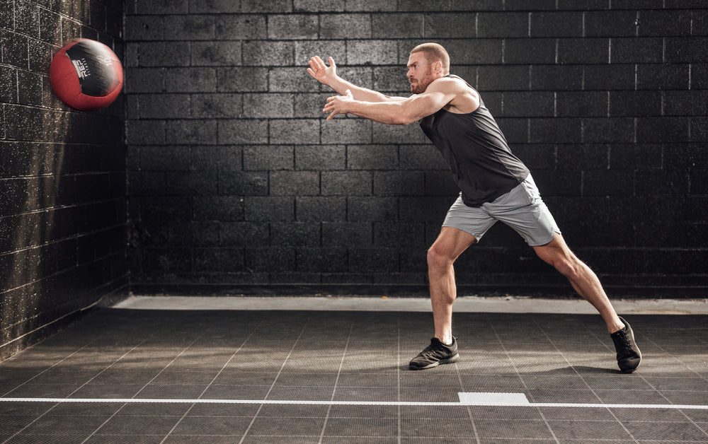 Athlete throwing a med ball wearing silver Men's Motus Shorts