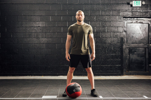 Athlete wearing Heather Olive Sigmatech Shirt with a med ball