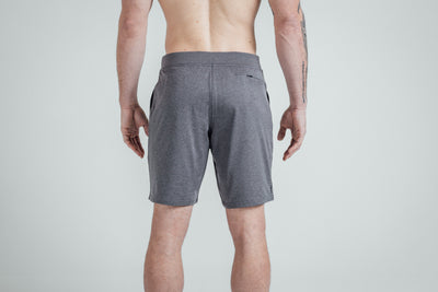 A close-up shot of the rear of REP’s Men’s Apollo Shorts with a 9 inch inseam in Heather Cool Gray/Black on a shirtless athlete. You can see the high-zip zipper pocket and the Smooth, Non-Scrunch Waistband.