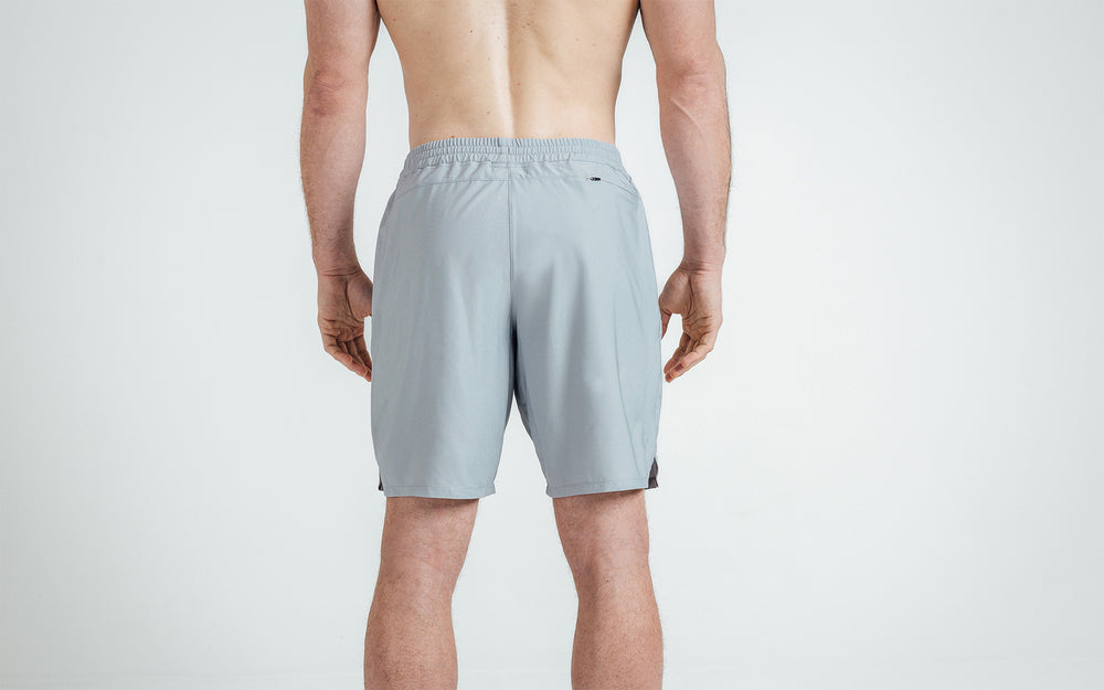 Athlete wearing silver Men's Motus Shorts, back view